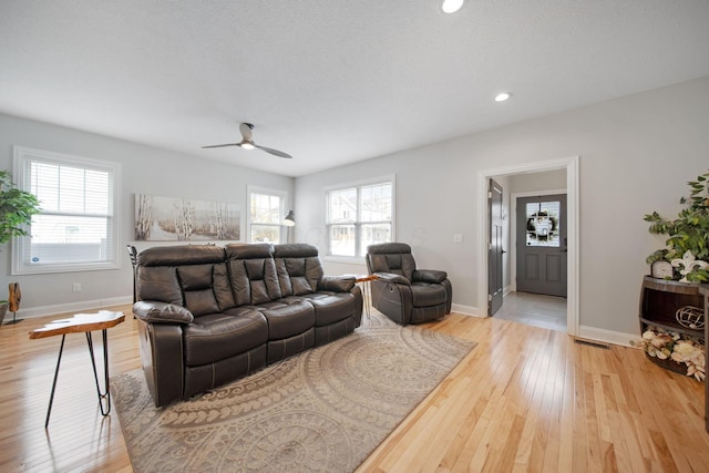 living area featuring baseboards, a ceiling fan, light wood finished floors, and recessed lighting