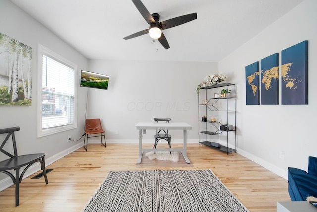 home office with light wood-style flooring, a ceiling fan, and baseboards