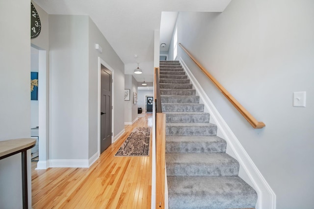 staircase with hardwood / wood-style flooring and baseboards