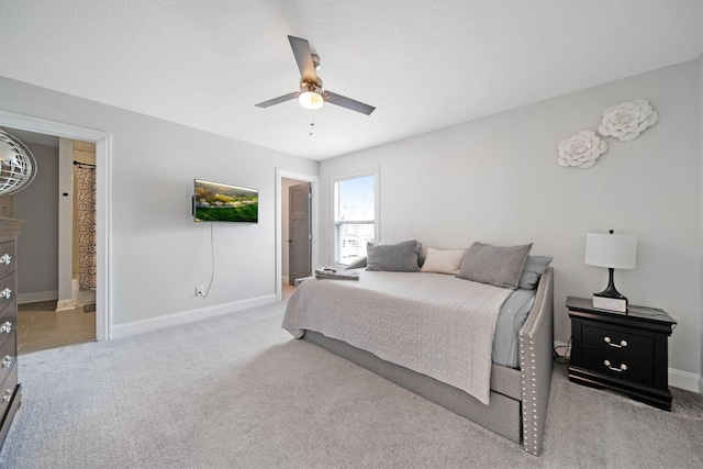 bedroom with carpet, baseboards, ceiling fan, and connected bathroom