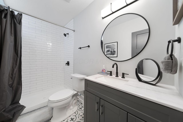 bathroom featuring toilet, vanity, and a stall shower