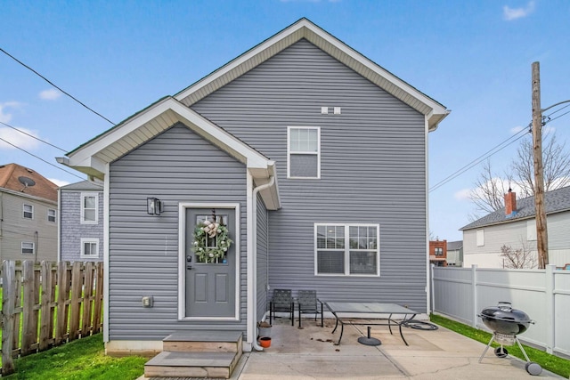 rear view of property featuring a patio area and a fenced backyard