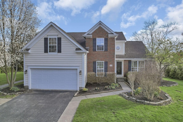 traditional-style house featuring a front lawn, brick siding, an attached garage, a shingled roof, and driveway