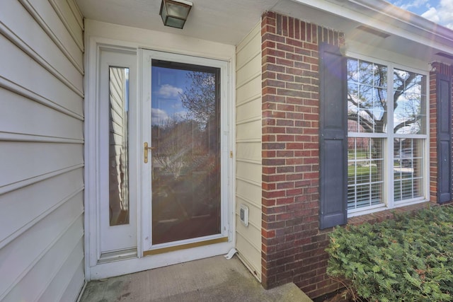 view of exterior entry with brick siding