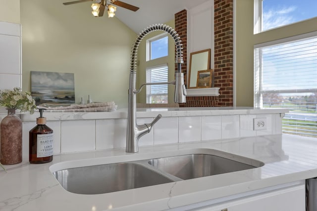 details featuring a sink, light stone counters, and ceiling fan