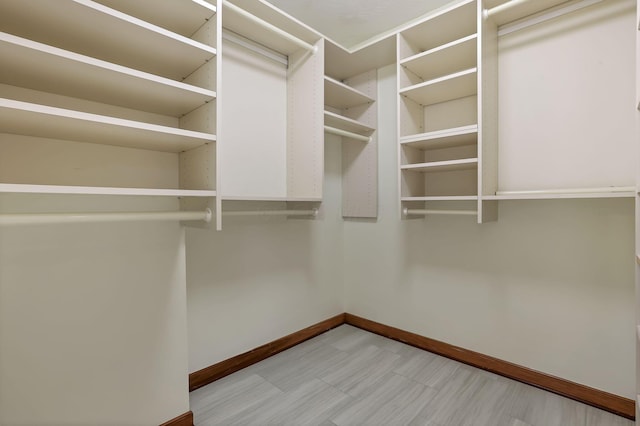 walk in closet with light floors
