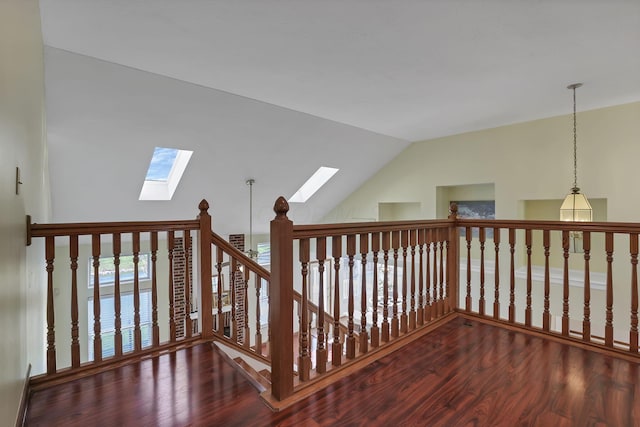 hall with lofted ceiling with skylight and wood finished floors