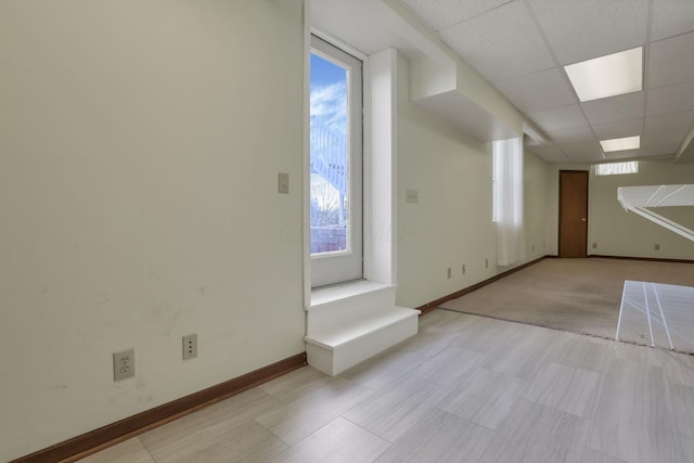 interior space with baseboards and a paneled ceiling