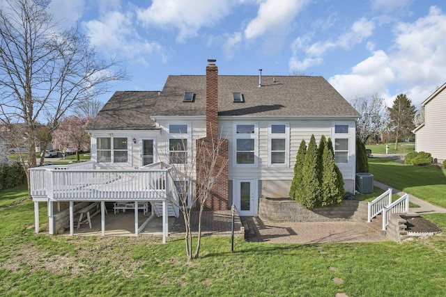 back of house featuring a shingled roof, a deck, central AC unit, and a lawn