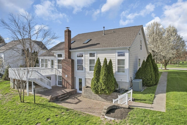 rear view of property featuring central AC, a shingled roof, a lawn, a chimney, and a wooden deck