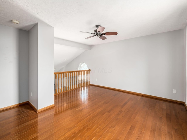 additional living space with vaulted ceiling, baseboards, wood finished floors, and ceiling fan
