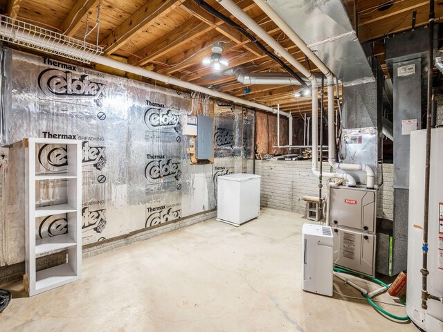 unfinished basement featuring fridge, electric panel, and water heater