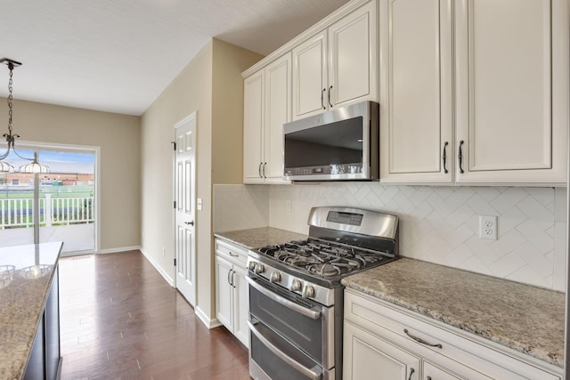 5351 Lilac Ave, Grove City, OH 43123 - kitchen with stainless steel appliances, decorative backsplash, dark wood finished floors, decorative light fixtures, and light stone counters