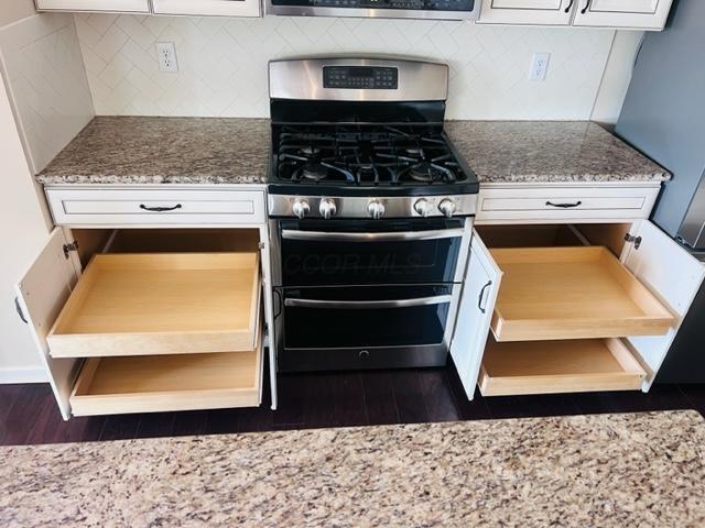 5351 Lilac Ave, Grove City, OH 43123 - kitchen with gas stove, dark wood finished floors, backsplash, and white cabinets