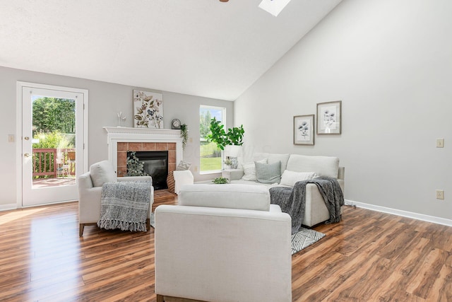 1148 Challis Springs Dr, New Albany, OH 43054 - living room with wood finished floors, a tile fireplace, baseboards, high vaulted ceiling, and a skylight