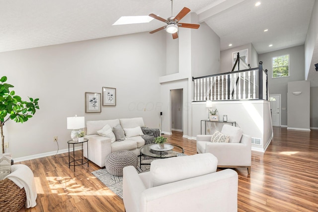 1148 Challis Springs Dr, New Albany, OH 43054 - living area featuring high vaulted ceiling, ceiling fan, wood finished floors, baseboards, and a skylight