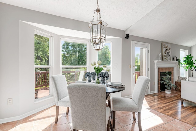 1148 Challis Springs Dr, New Albany, OH 43054 - dining area featuring a chandelier, healthy amount of natural light, light tile patterned flooring, a textured ceiling, and baseboards