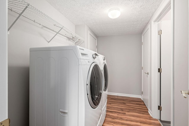 1148 Challis Springs Dr, New Albany, OH 43054 - washroom with separate washer and dryer, wood finished floors, a textured ceiling, baseboards, and cabinet space