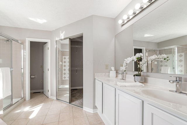1148 Challis Springs Dr, New Albany, OH 43054 - full bathroom with a textured ceiling, double vanity, a stall shower, tile patterned floors, and a walk in closet