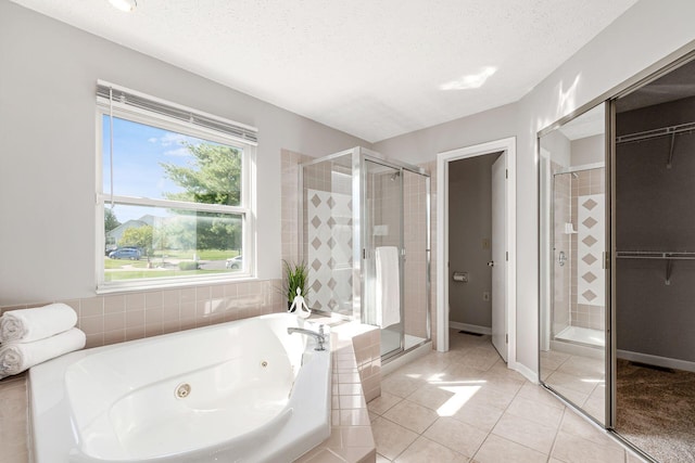 1148 Challis Springs Dr, New Albany, OH 43054 - bathroom featuring a shower stall, a whirlpool tub, tile patterned flooring, a textured ceiling, and a walk in closet