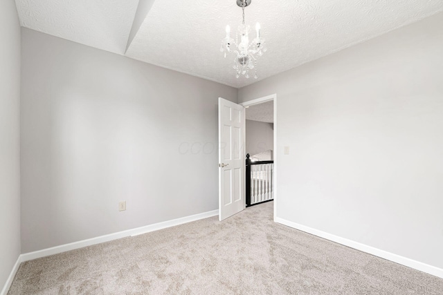 1148 Challis Springs Dr, New Albany, OH 43054 - empty room featuring carpet floors, a chandelier, a textured ceiling, and baseboards