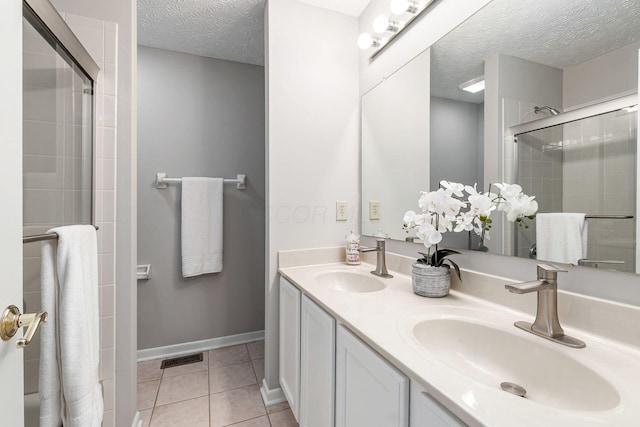 1148 Challis Springs Dr, New Albany, OH 43054 - bathroom with a textured ceiling, a tile shower, double vanity, tile patterned floors, and baseboards