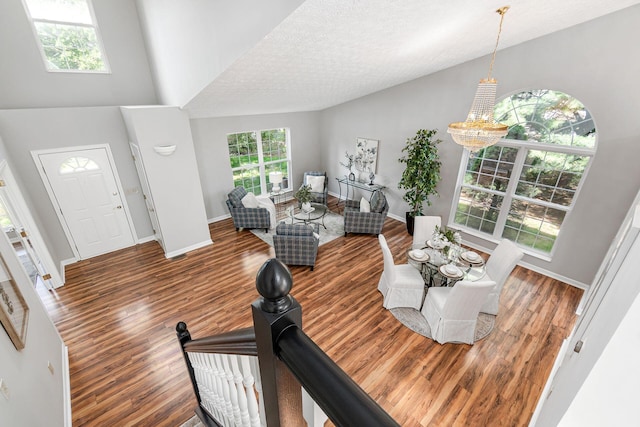 1148 Challis Springs Dr, New Albany, OH 43054 - living room featuring wood finished floors, a chandelier, baseboards, a towering ceiling, and a textured ceiling