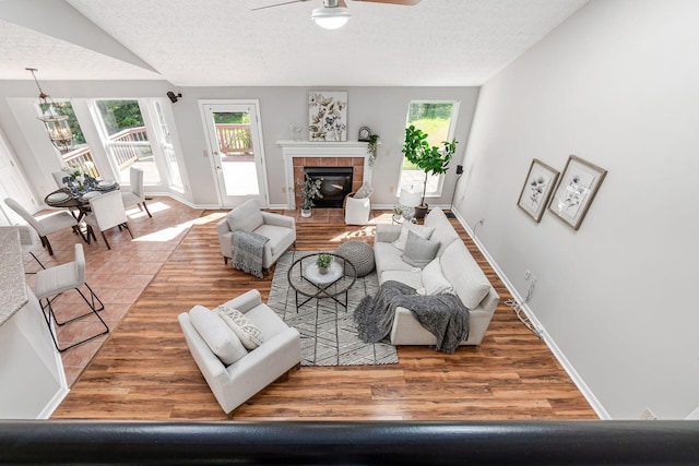 1148 Challis Springs Dr, New Albany, OH 43054 - living area featuring ceiling fan, plenty of natural light, a textured ceiling, a tile fireplace, and wood finished floors