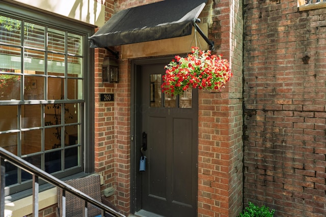 doorway to property with brick siding
