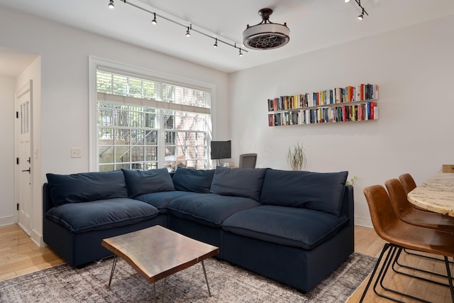 living area featuring rail lighting and wood finished floors