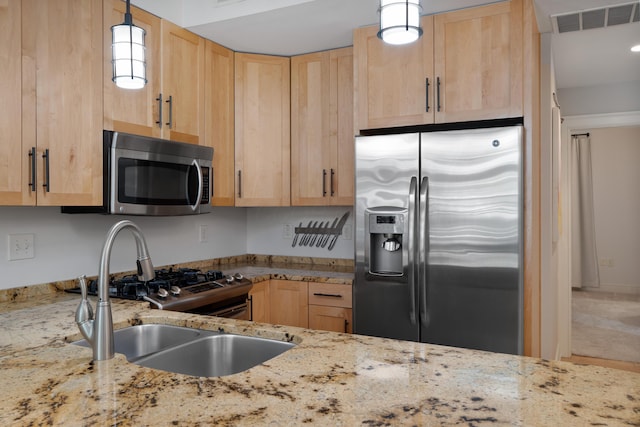 kitchen featuring appliances with stainless steel finishes, a sink, visible vents, and light brown cabinets