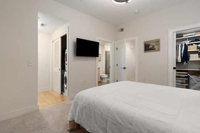 bedroom with visible vents, stacked washer and clothes dryer, a closet, and a spacious closet