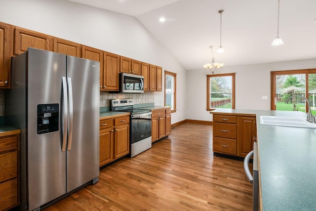 277 Cherrington Rd, Westerville, OH 43081 - kitchen with tasteful backsplash, brown cabinets, lofted ceiling, stainless steel appliances, and a sink