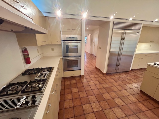 kitchen featuring under cabinet range hood, white cabinets, appliances with stainless steel finishes, and light countertops