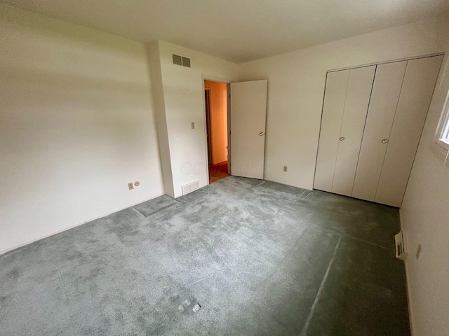 unfurnished bedroom featuring a closet, visible vents, and carpet