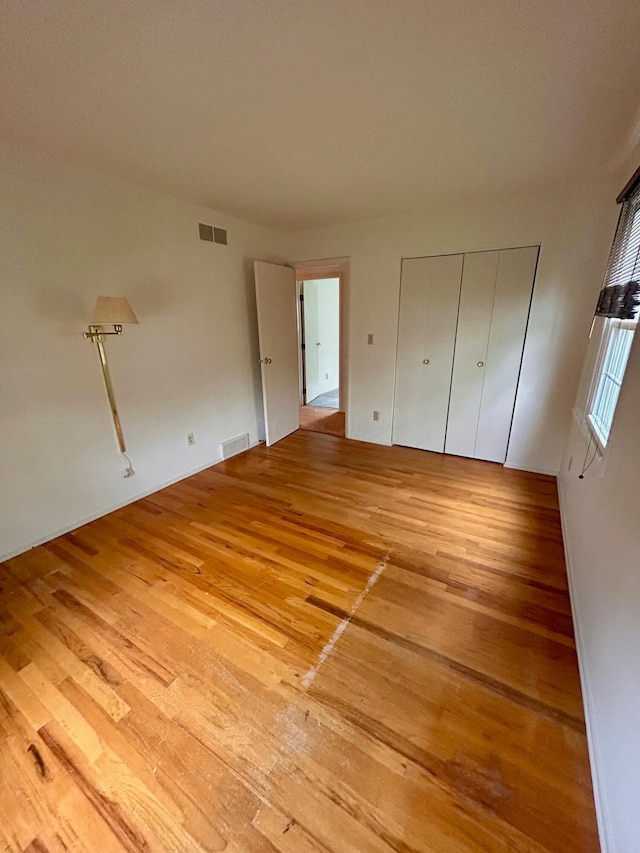 unfurnished bedroom featuring light wood-type flooring and visible vents