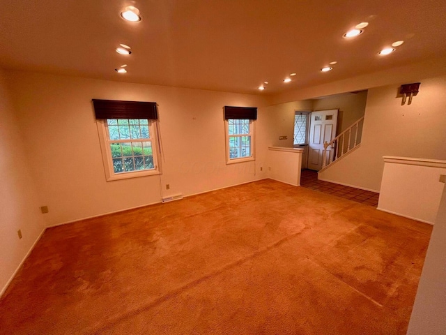 empty room featuring stairway, recessed lighting, visible vents, and carpet
