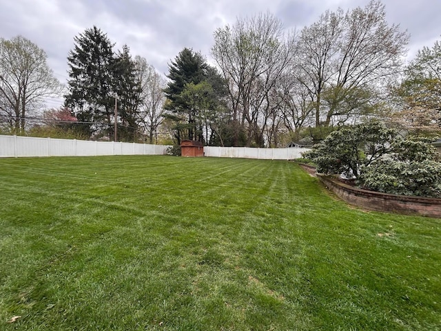 view of yard featuring fence, an outbuilding, and a storage shed