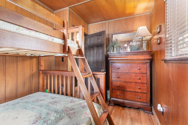 bedroom with wooden ceiling, wood walls, and wood finished floors