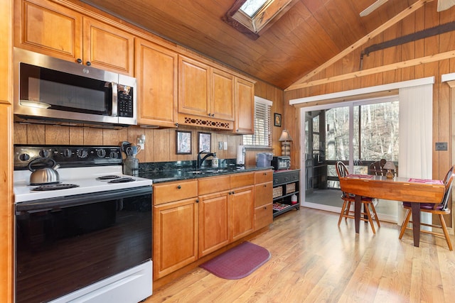 kitchen featuring light wood-style flooring, wooden ceiling, stainless steel microwave, range with electric stovetop, and lofted ceiling with skylight