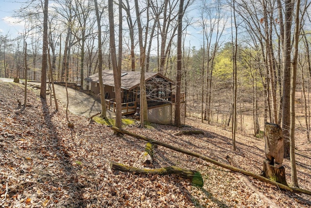 view of yard with a wooden deck and a forest view