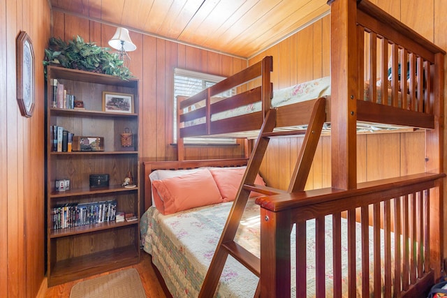 bedroom featuring wooden walls, wooden ceiling, and wood finished floors
