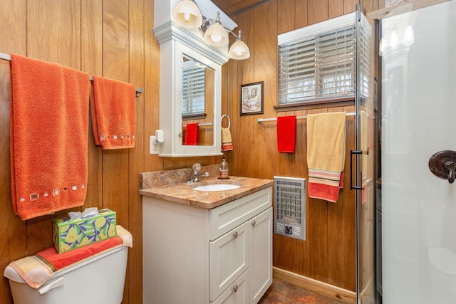 bathroom with wooden walls, heating unit, vanity, and a shower with shower door
