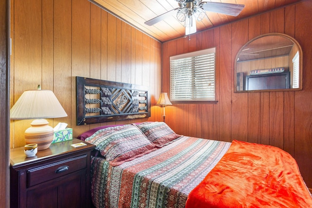 bedroom with wooden walls and a ceiling fan