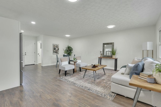 living room with dark wood-style floors, recessed lighting, and a textured ceiling