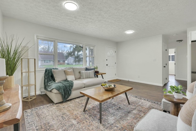 living area with a textured ceiling, wood finished floors, and baseboards
