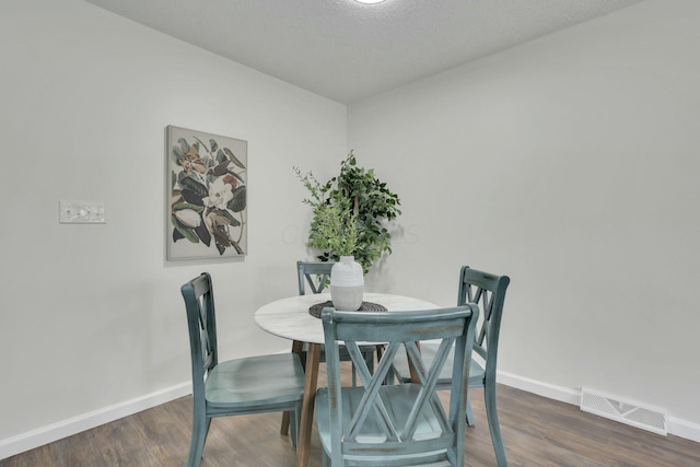 dining room featuring visible vents, baseboards, and dark wood finished floors