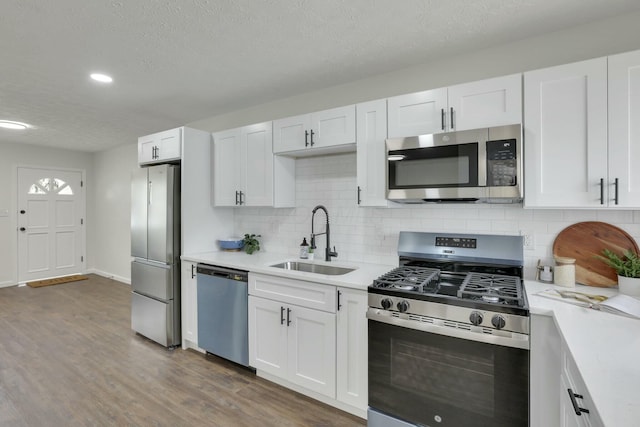 kitchen with a sink, light countertops, white cabinetry, and stainless steel appliances