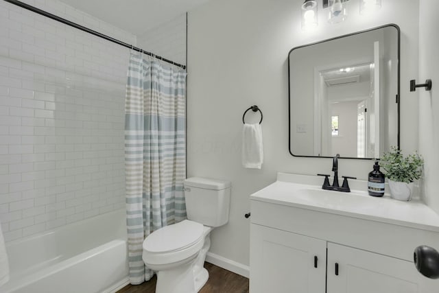 bathroom featuring vanity, toilet, wood finished floors, shower / bath combo with shower curtain, and baseboards