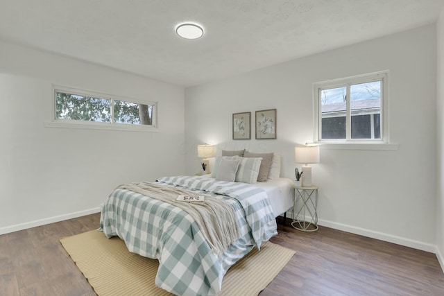 bedroom with baseboards and wood finished floors